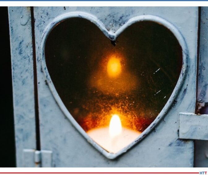 A metal cutout of a heart through which a flame can be seen