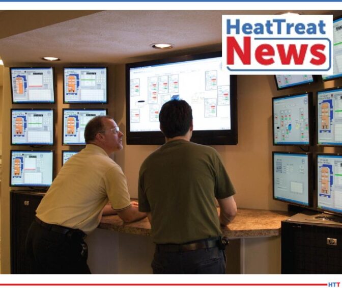 Two men looking at a bank of computer screens